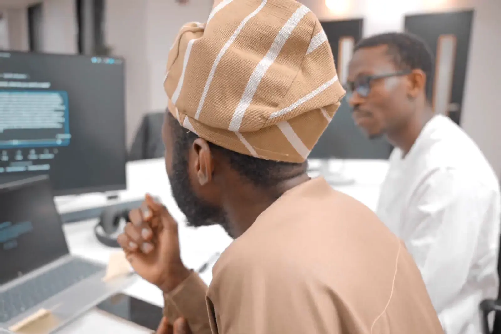 Two participants reviewing code on a monitor