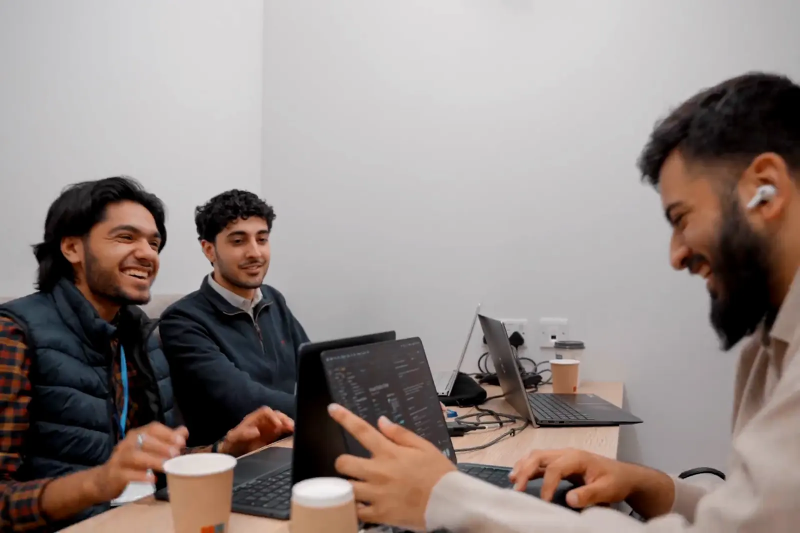 Three participants laughing over their laptops